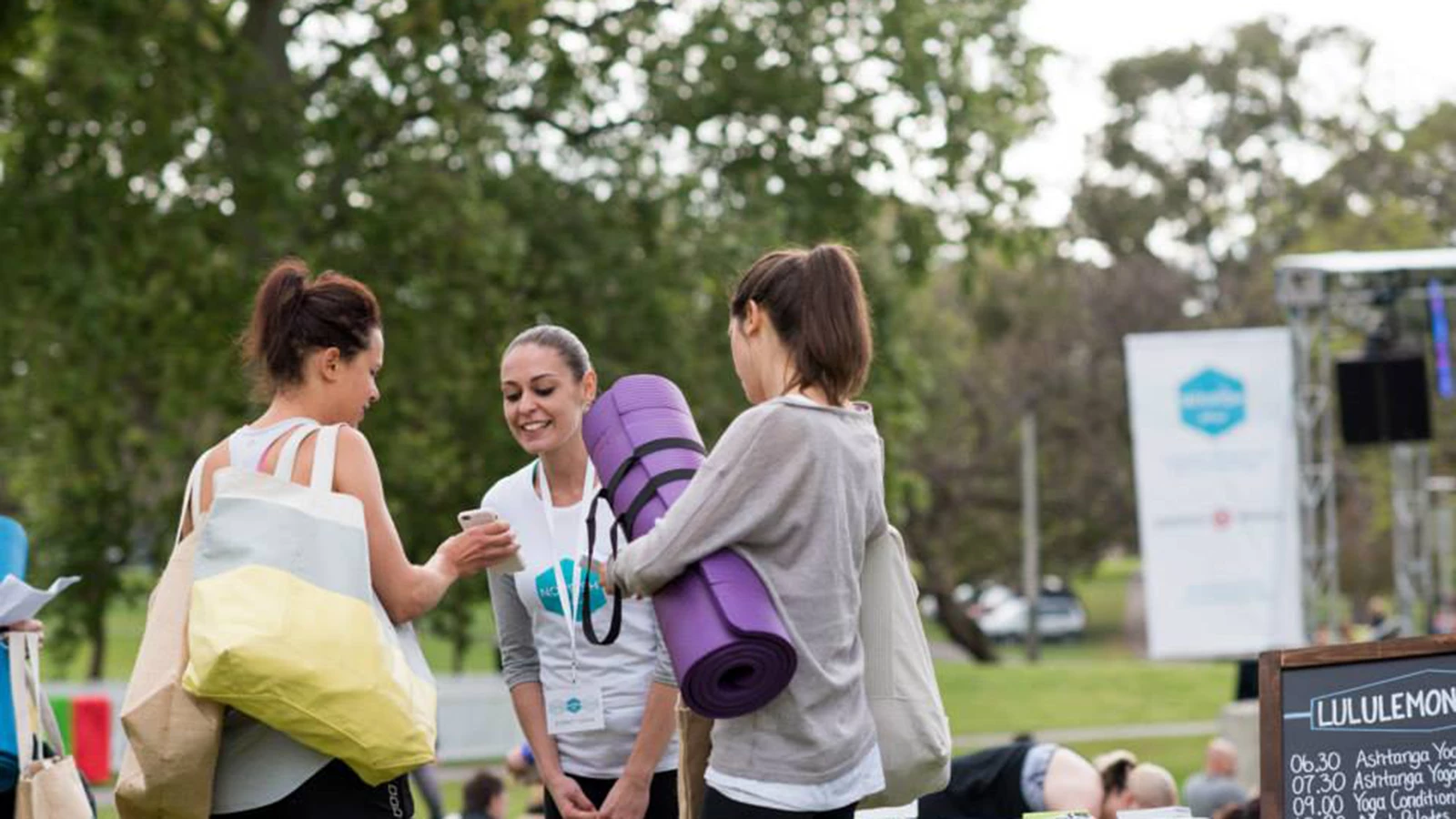 Nourish Festival fitness instructors in event shirts and event banners in background.